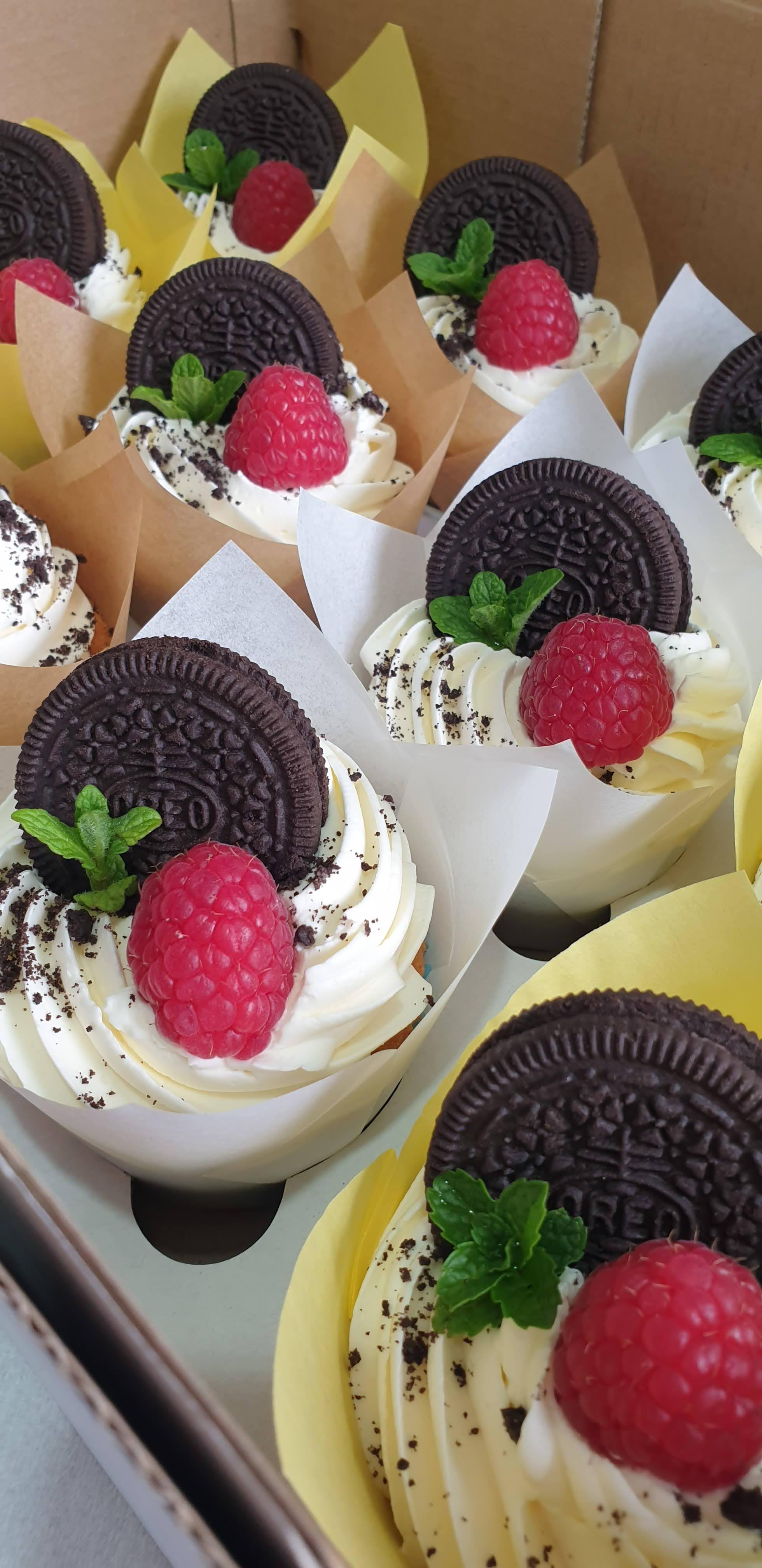 Cupcakes with white buttercream frosting, crushed oreo biscuit crumbles, whole oreo cookies