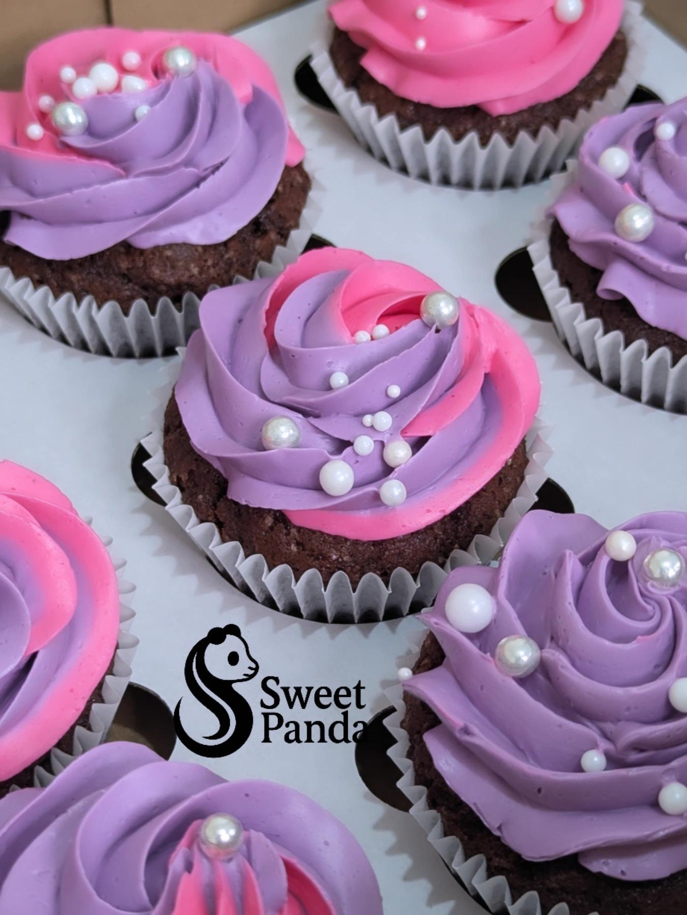 Chocolate cupcakes with pink and purple ombre buttercream piped in rose swirls, topped with white pearl beads