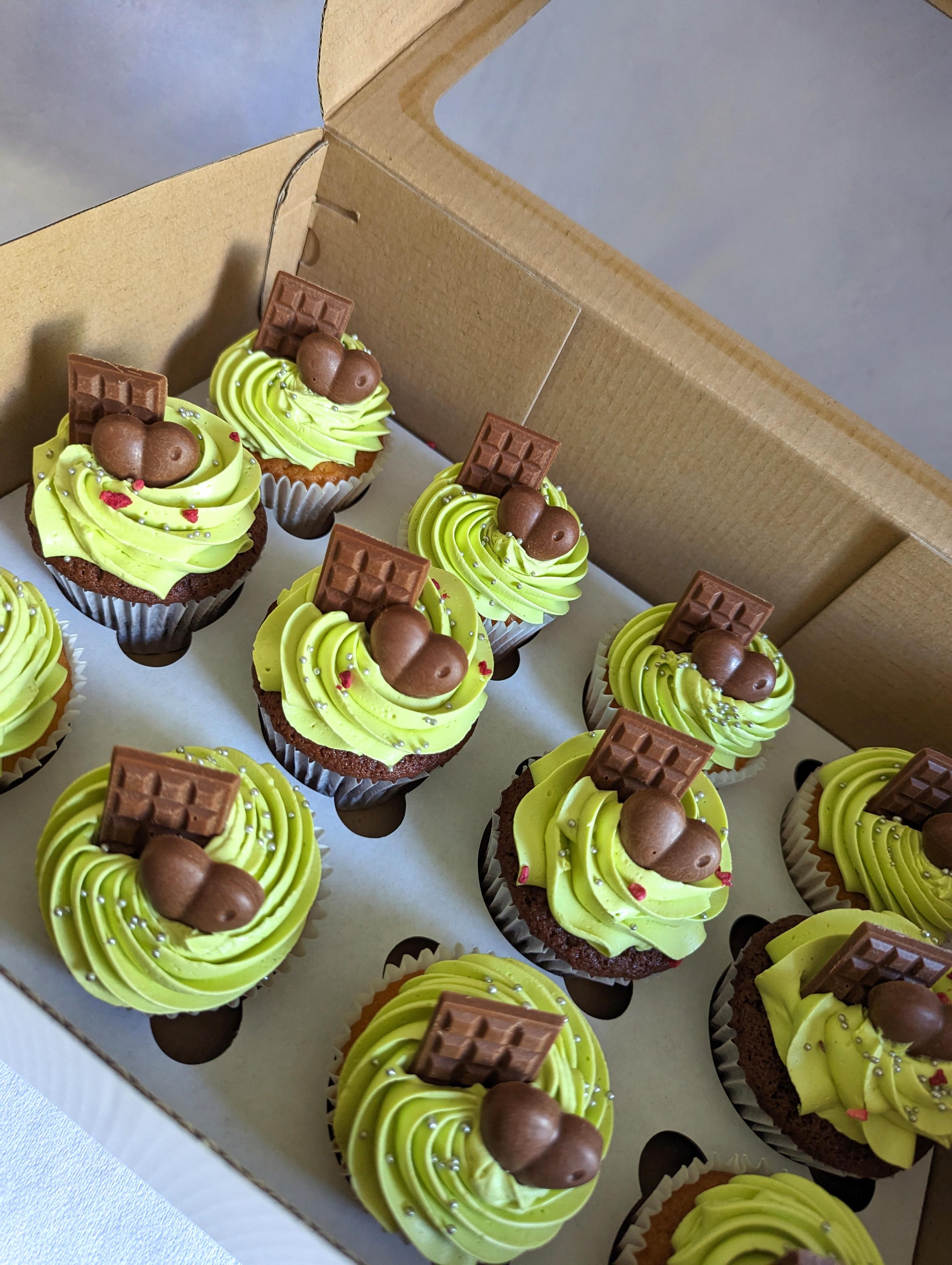 Chocolate cupcakes with pistachio-green buttercream swirls, topped with chocolate wafers and chocolate truffles