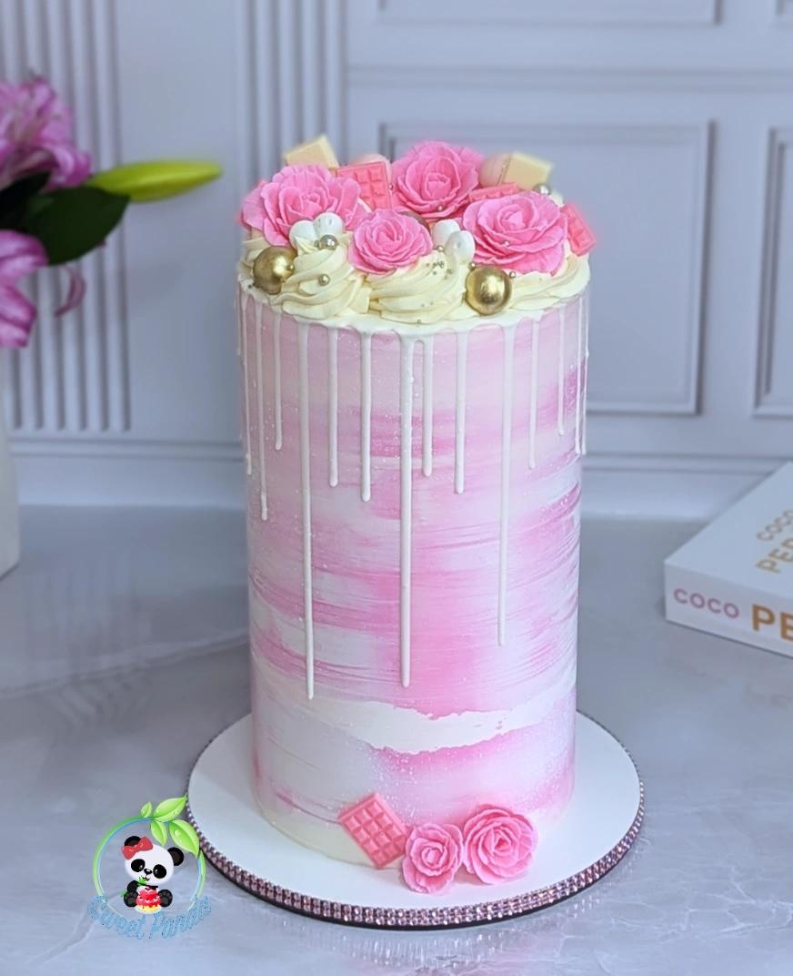 Pink celebration cake with white drip, textured pink and white buttercream