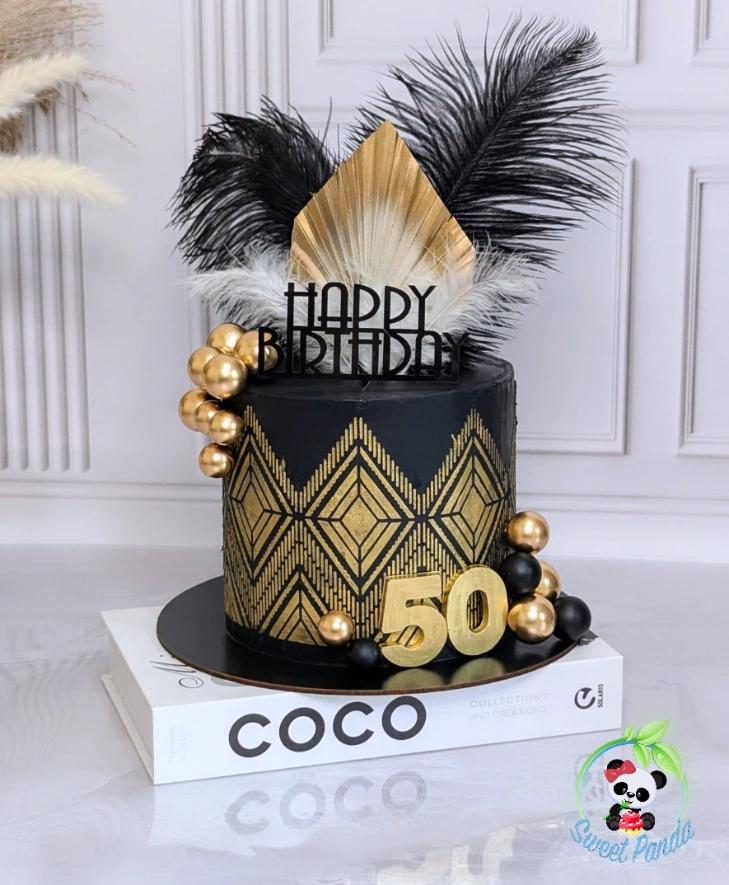 Black and gold art deco celebration cake with black feathers, gold geometric patterns