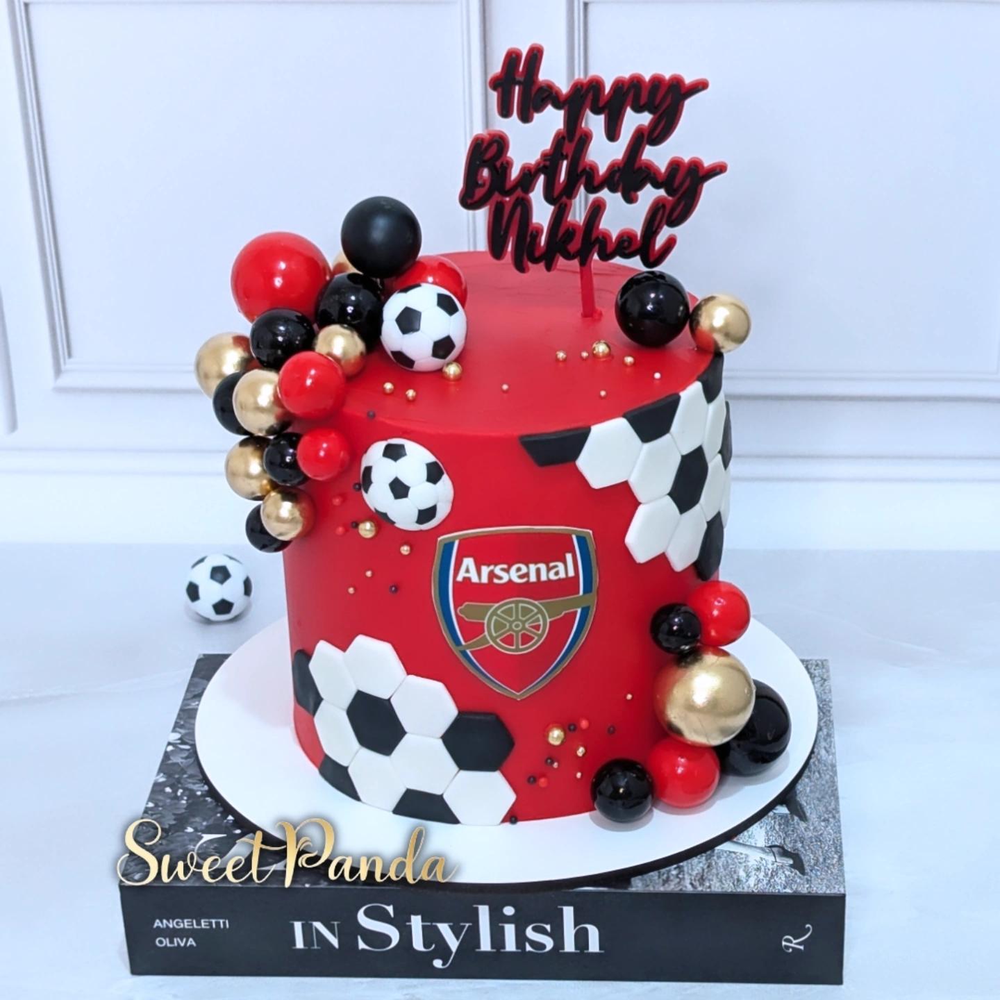 Red fondant cake decorated with Arsenal FC badge, black and white football patterns