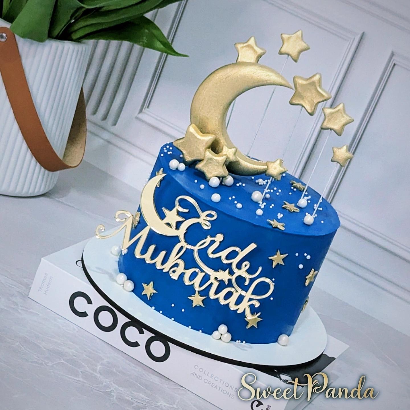 Blue fondant celebration cake with gold crescent moon and star topper, decorated with gold stars and white pearls