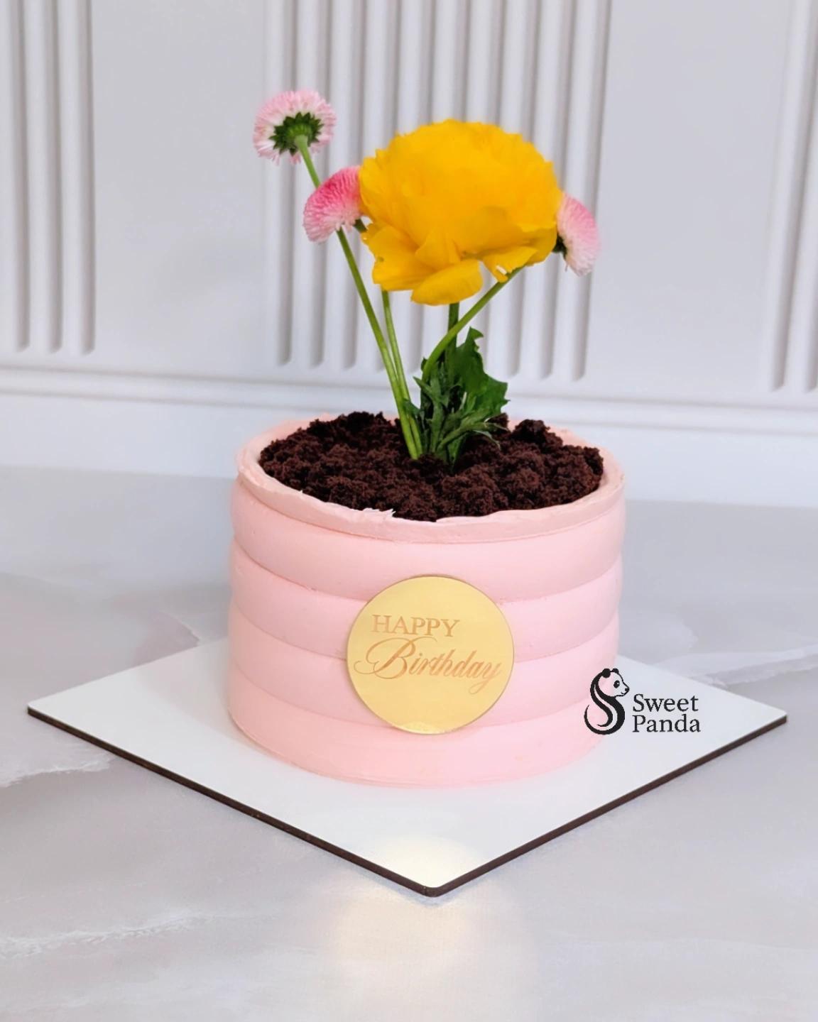Pink buttercream birthday cake with gold disc topper