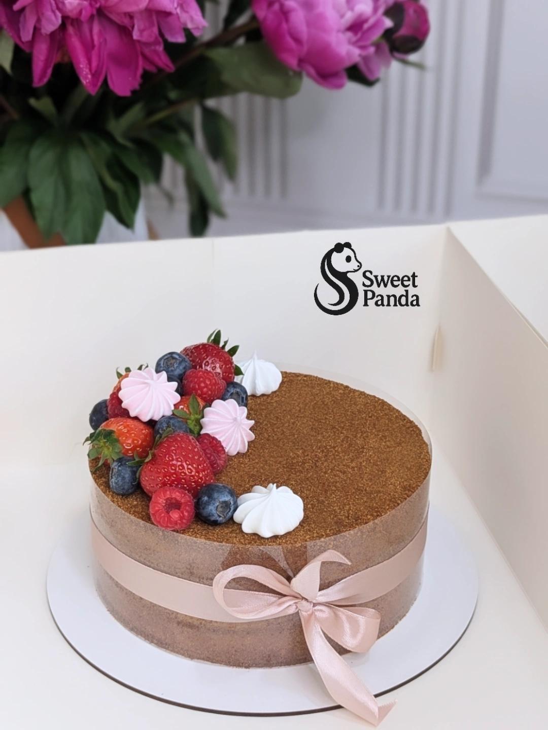 Single-tier honey cake with chocolate ganache top, decorated with fresh strawberries, raspberries