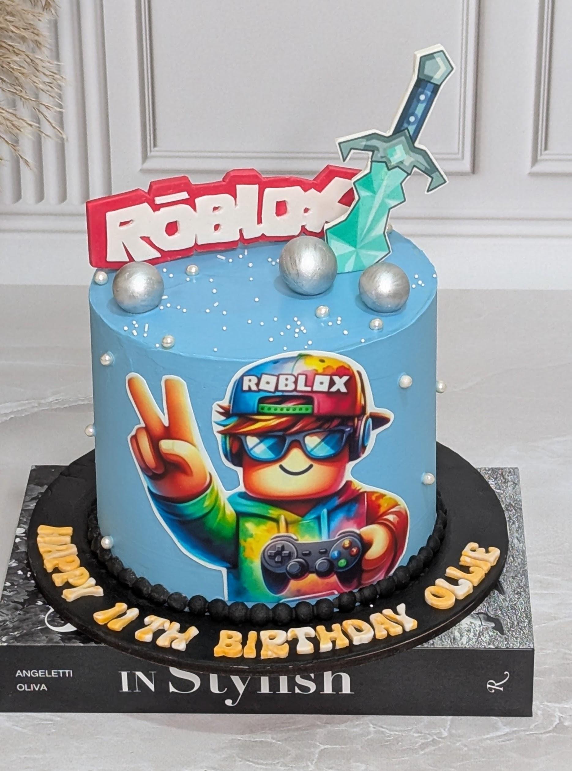 Blue fondant cake with Roblox character printed image, green pixelated sword topper, silver ball decorations