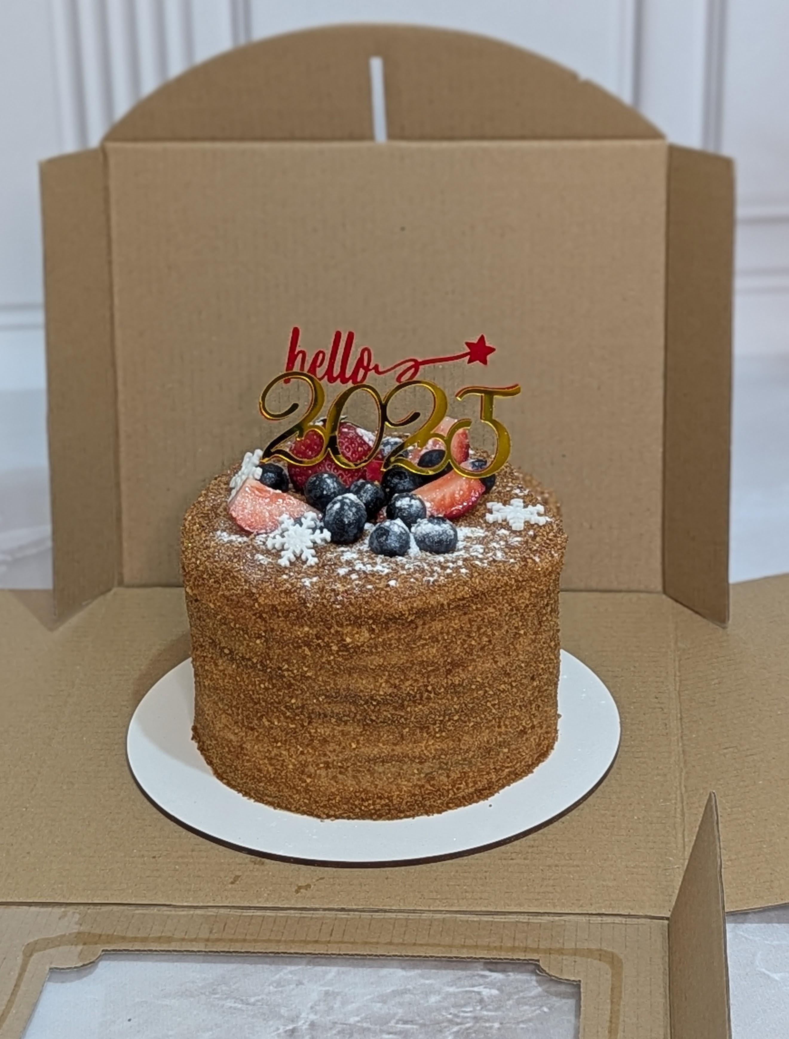 Single-tier cake with textured brown buttercream, topped with blueberries, raspberries and icing sugar