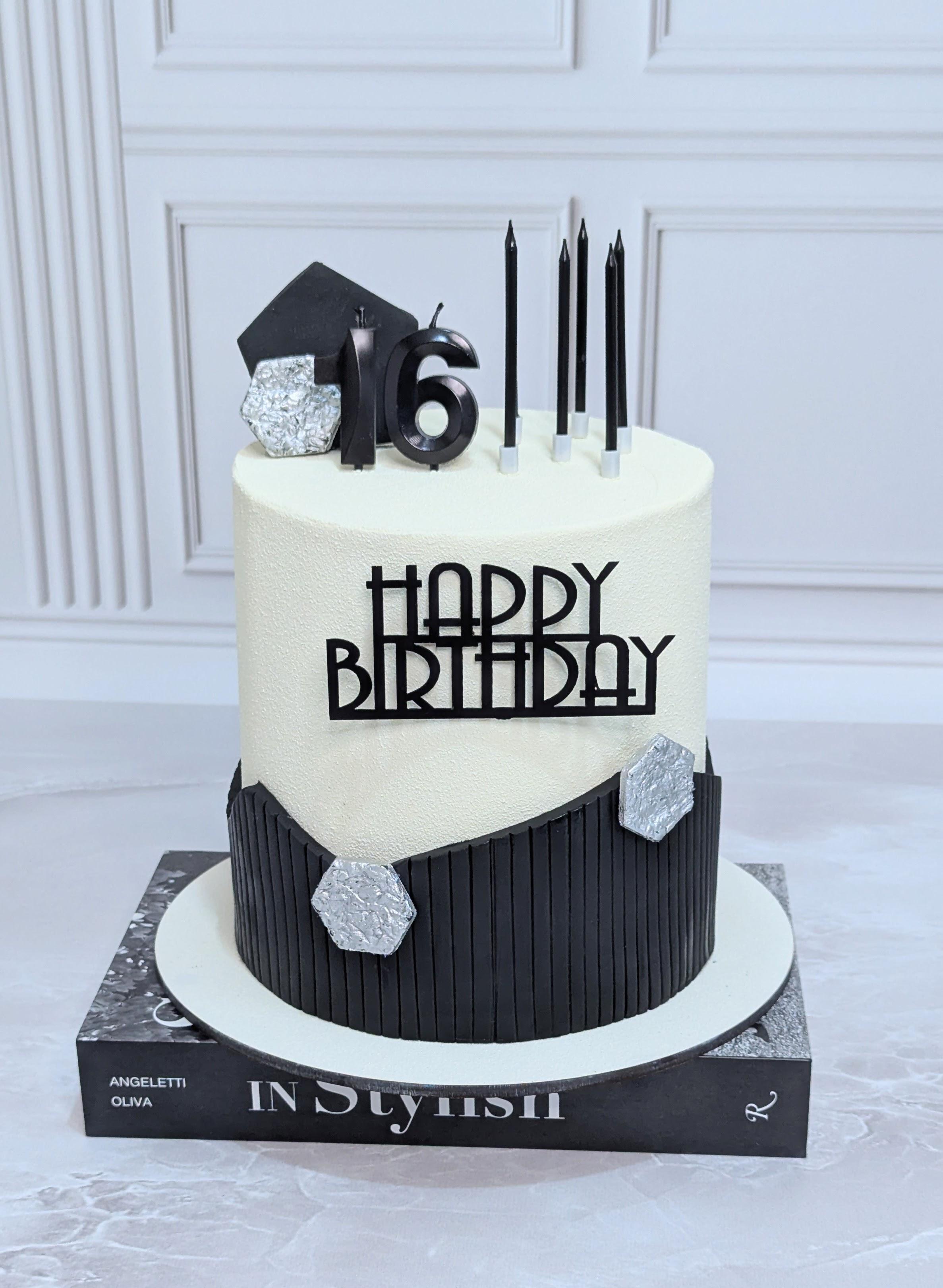 Two-tier celebration cake with cream fondant top, black ribbed fondant base, silver hexagonal gems
