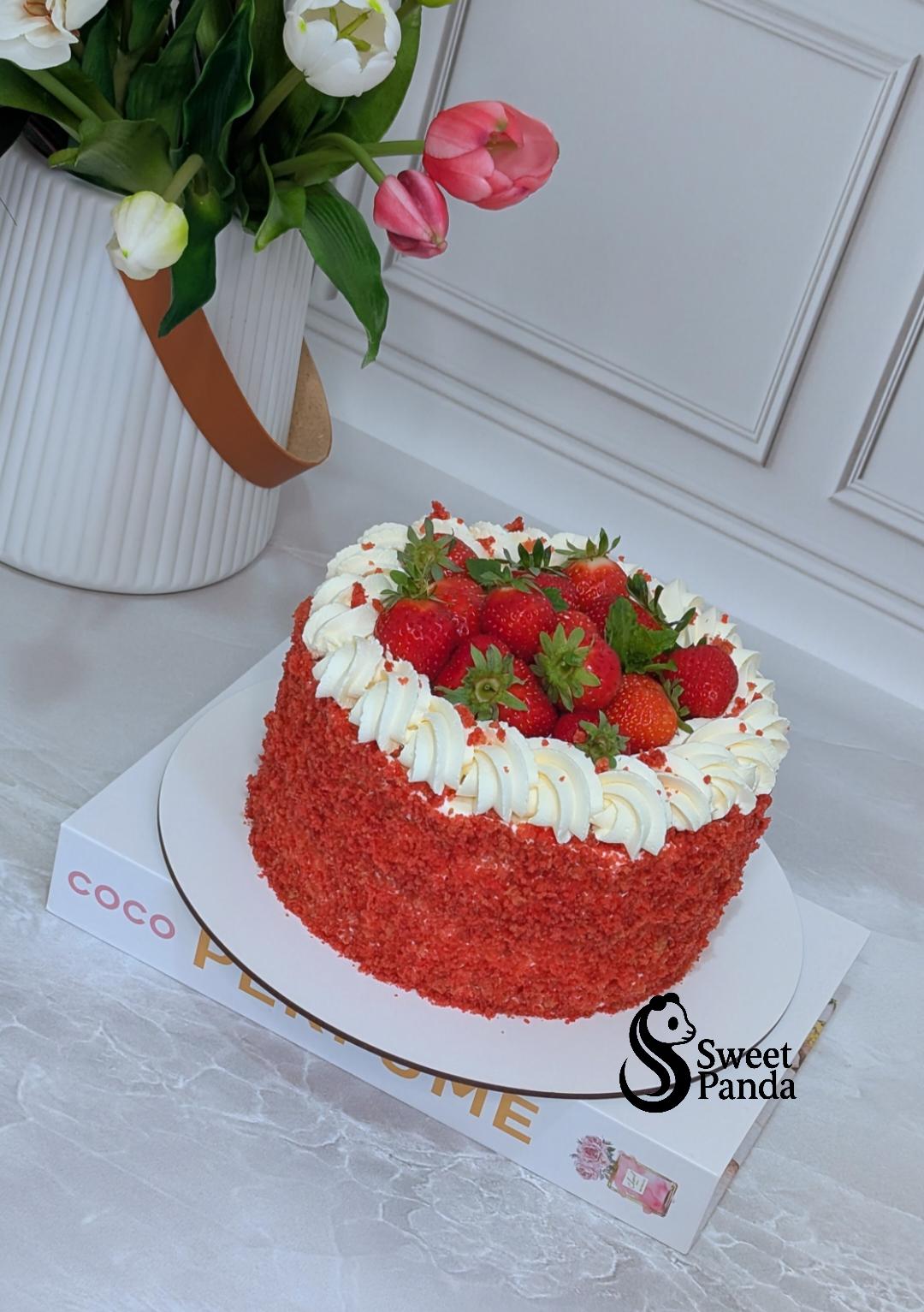 Red velvet layer cake with textured red buttercream, white piped rosettes and fresh strawberries on top
