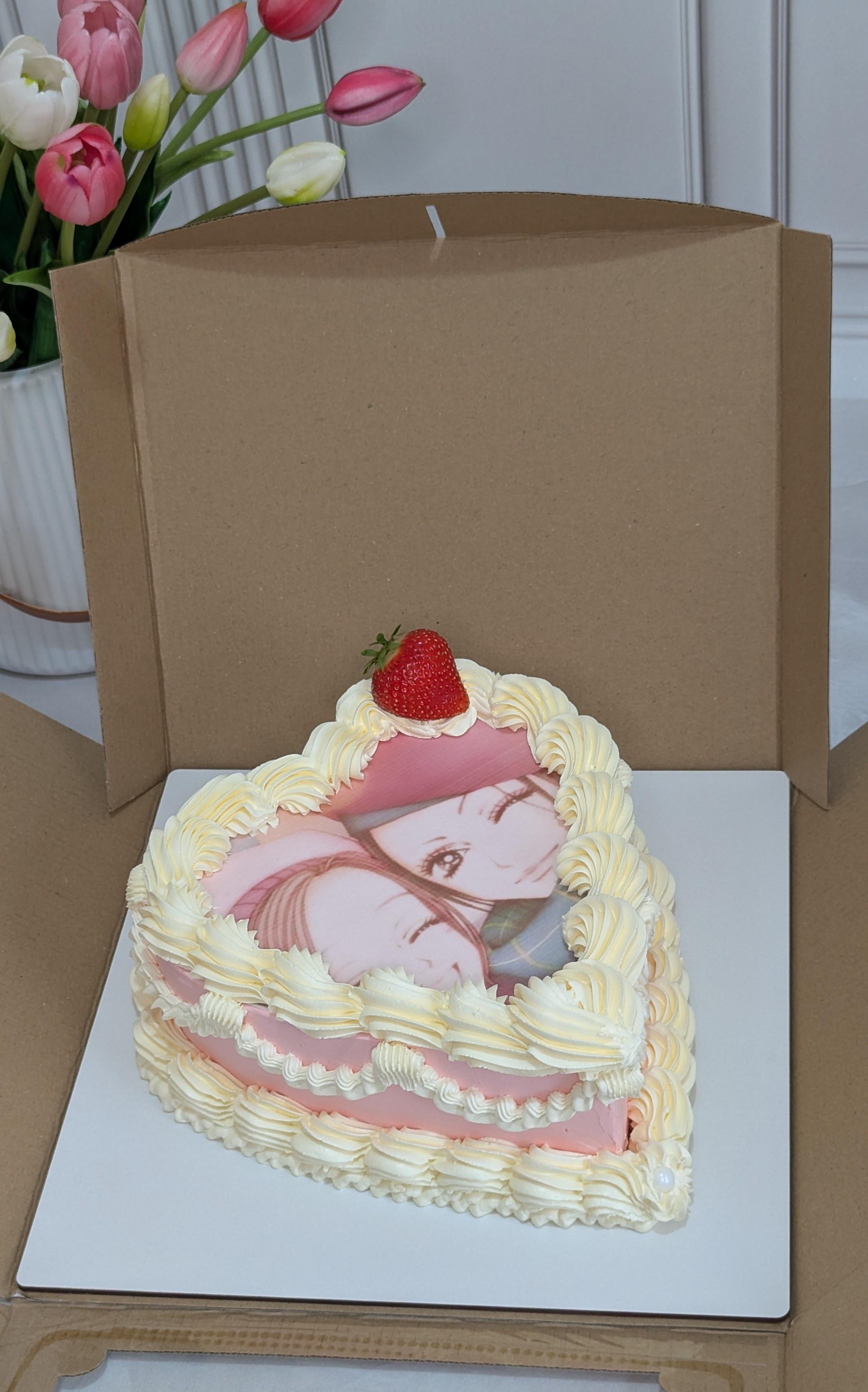 Two-tier cake with cream textured buttercream, pink fondant layers, anime character printed image
