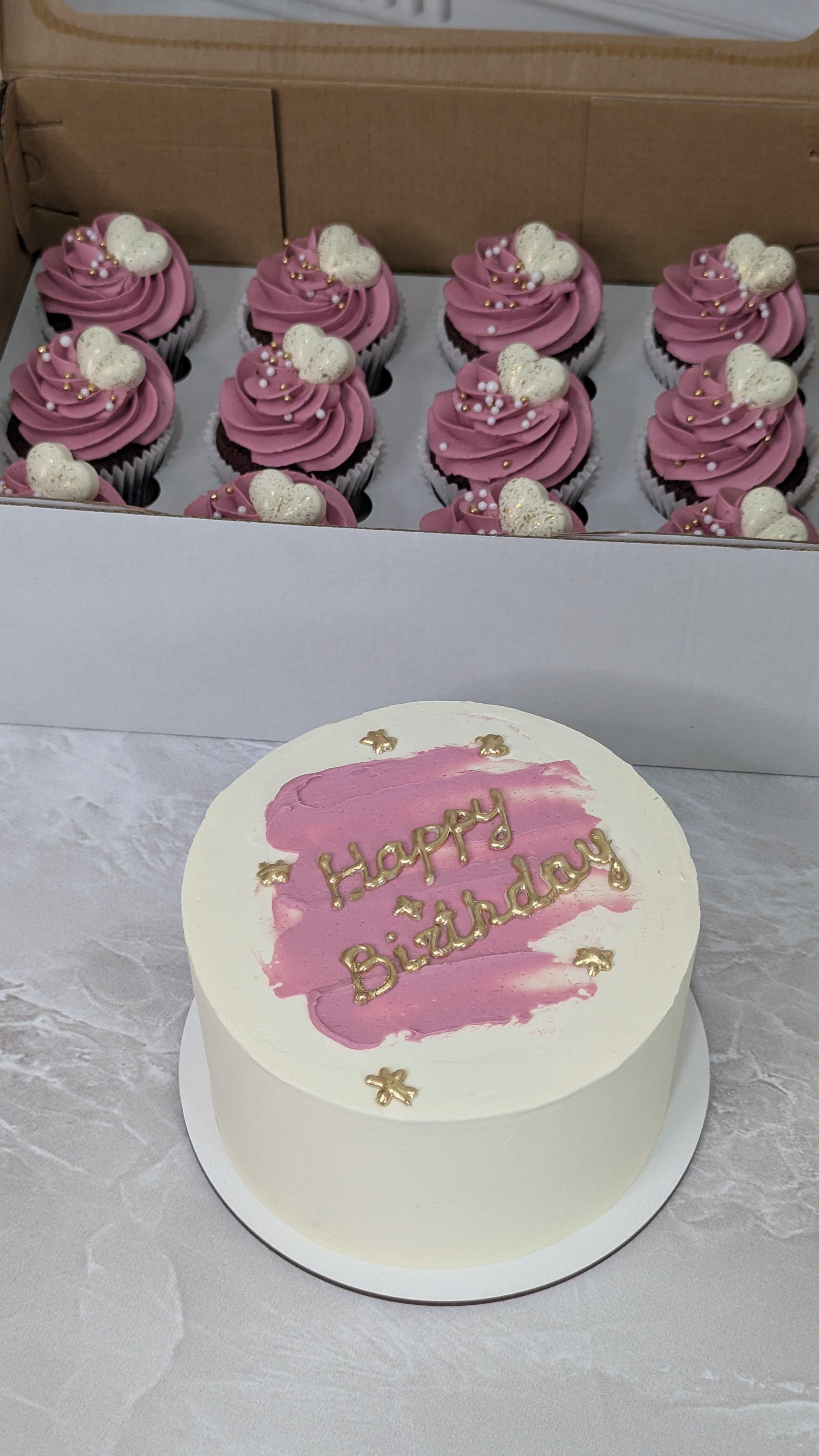 White celebration cake with mauve pink brushstroke and gold lettering