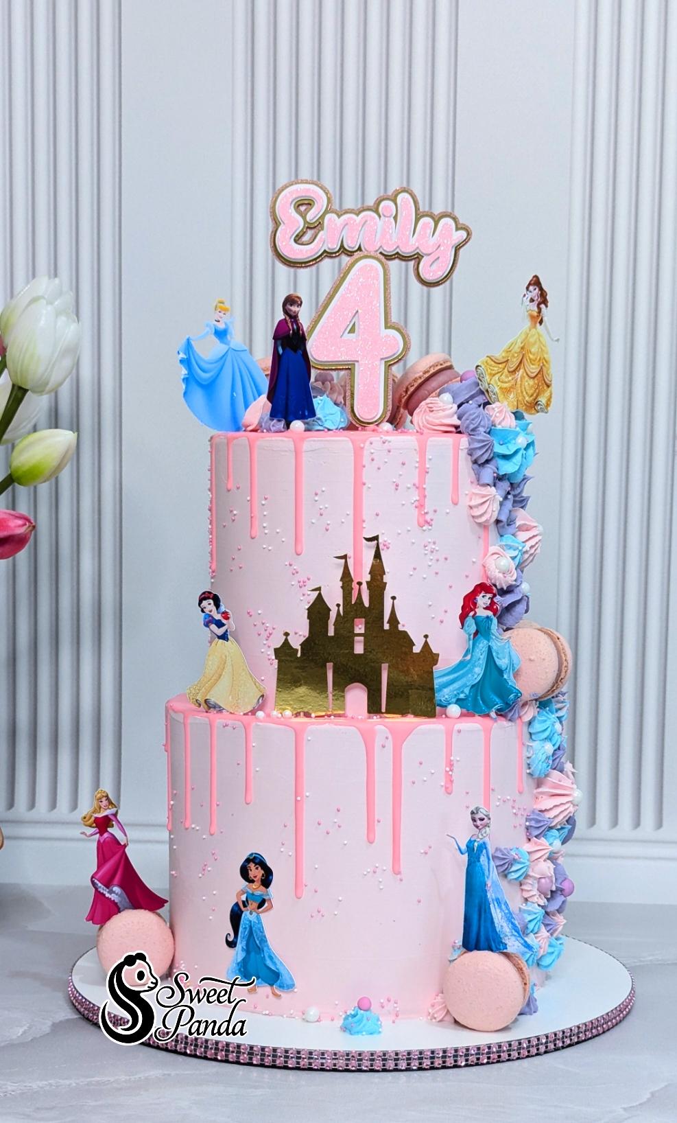 Two-tier pink buttercream birthday cake with Disney Princess figurines, gold castle topper and name topper